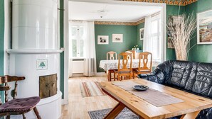En hyggelig stue med pejs, træmøbler og en grøn væg.