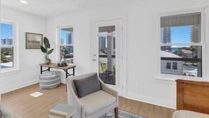 A modern living room with a sofa, a small table, and a potted plant.
