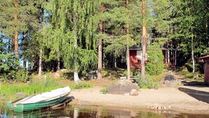 Una baita sul lago, circondata da alberi.