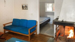 Una stanza accogliente con un divano blu, un letto e un caminetto.