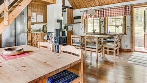 A rustic cabin interior with a wooden dining table, benches, a kitchen area with a stove, and a staircase. - Ängasjö by Interhome (Östra Frölunda)