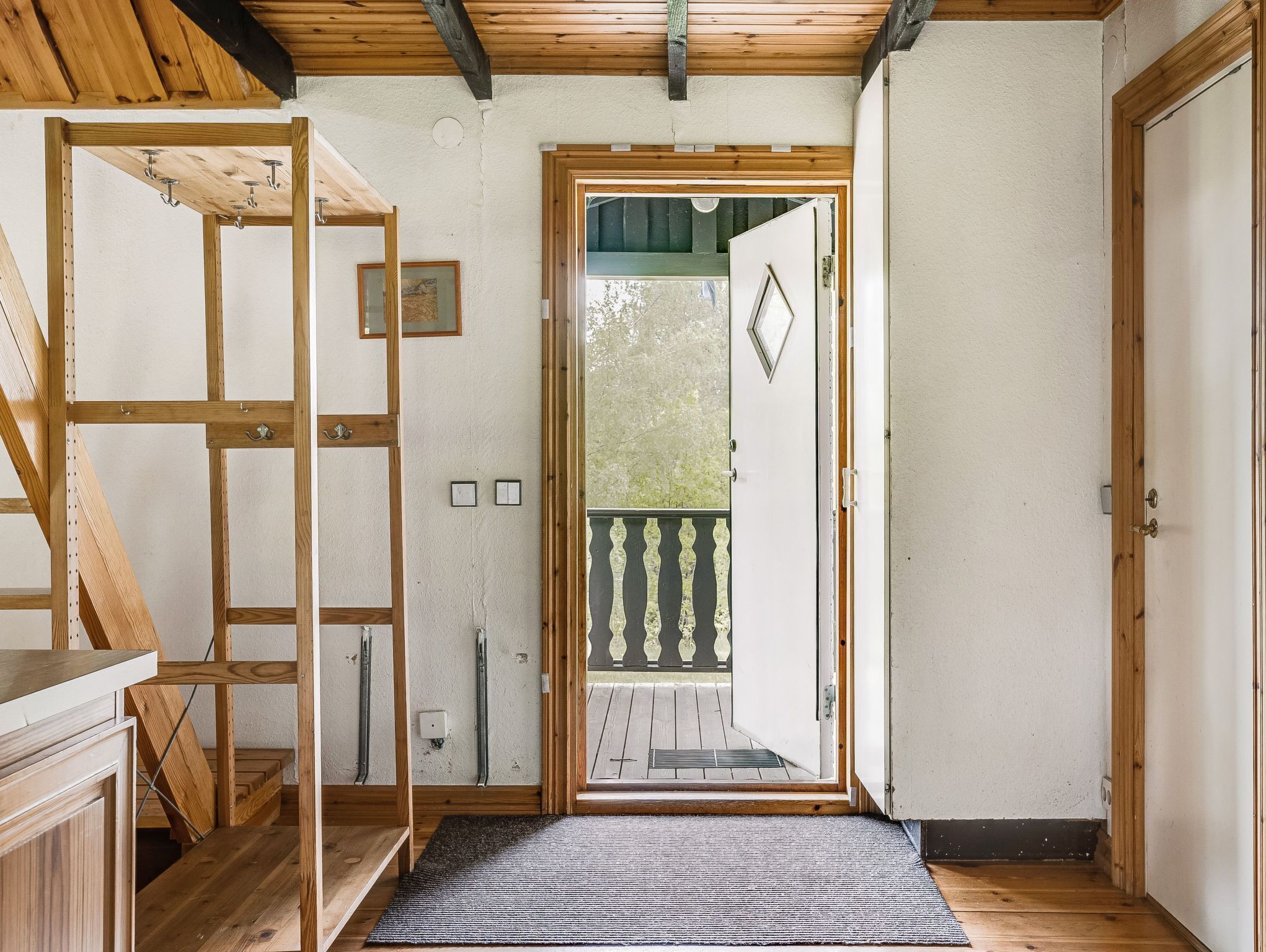 Een houten interieur met een deur die leidt naar een balkon.