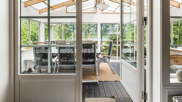 Ein modernes Interieur mit einer Glastür, die zu einem Außenbereich mit Terrasse führt.