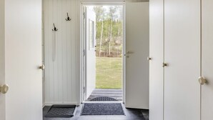 A hallway leading to a door with a view of a grassy yard and trees. - Björkebo by Interhome (Ätran)