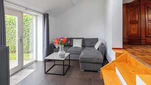 A modern living room with a grey sofa, a coffee table, and a wooden cabinet.