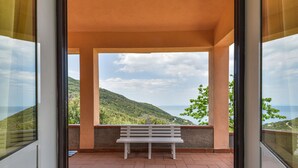 A balcony with a bench, offering a view of a mountainous landscape and the sea. - La Paradisa by Interhome (Nisportino)