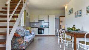 A compact apartment with a kitchen, dining area, and a staircase. - La Paradisa by Interhome (Nisportino)