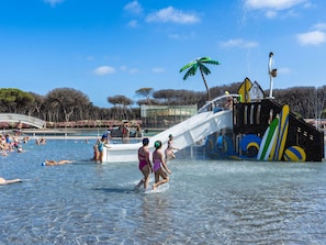 A water park with a pool, slides, and a playground area.