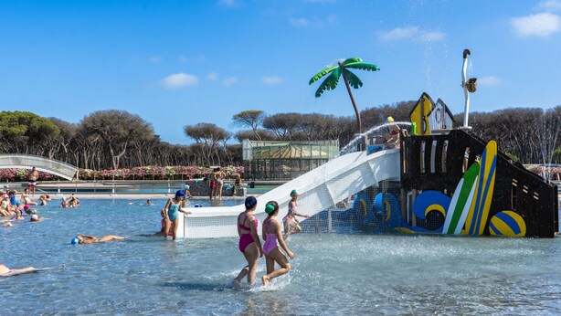 Parque aquático com piscina, toboáguas e área de recreação infantil.