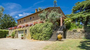 Une maison en pierre avec un escalier en pierre menant à un garage.