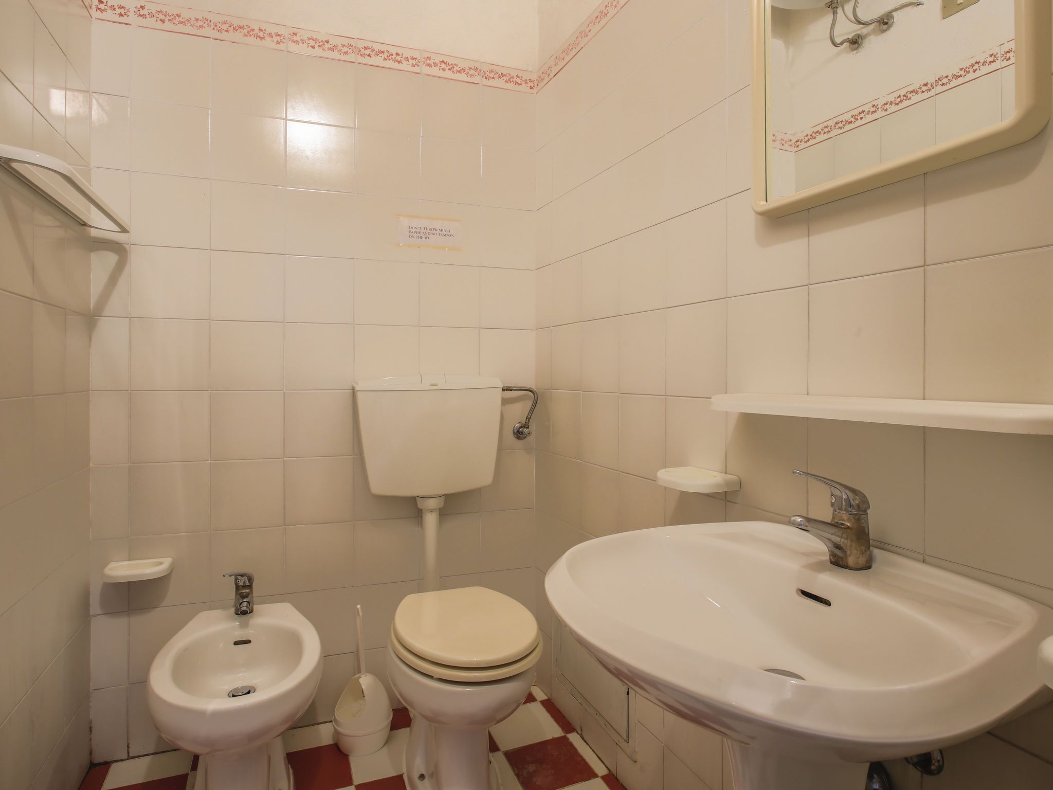 A bathroom with a toilet, bidet, and sink.