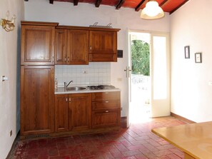 Kjøleskap, høy barnestol, kjøkkenutstyr og spisebord