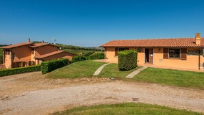 A two-story house with a tiled roof, a gravel driveway, and a well-maintained lawn. - Terrazza by Interhome (Istia d'Ombrone)