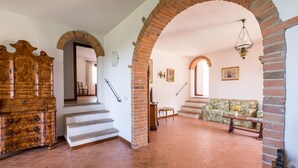Ein großzügiger Wohnbereich mit Treppe, Holzmöbeln und einer Couch.