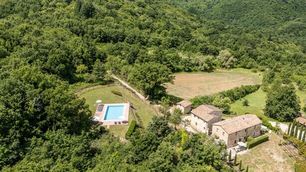 A villa with a swimming pool surrounded by lush greenery and hills. - Apartment Arco by Interhome (Travale)