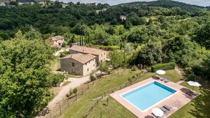 A villa with a swimming pool, surrounded by lush greenery and hills. - Apartment Arco by Interhome (Travale)