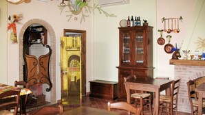 Ein Essbereich mit Holztisch und -stühlen, einer Schrank mit Glastüren und einer Ziegelwand.