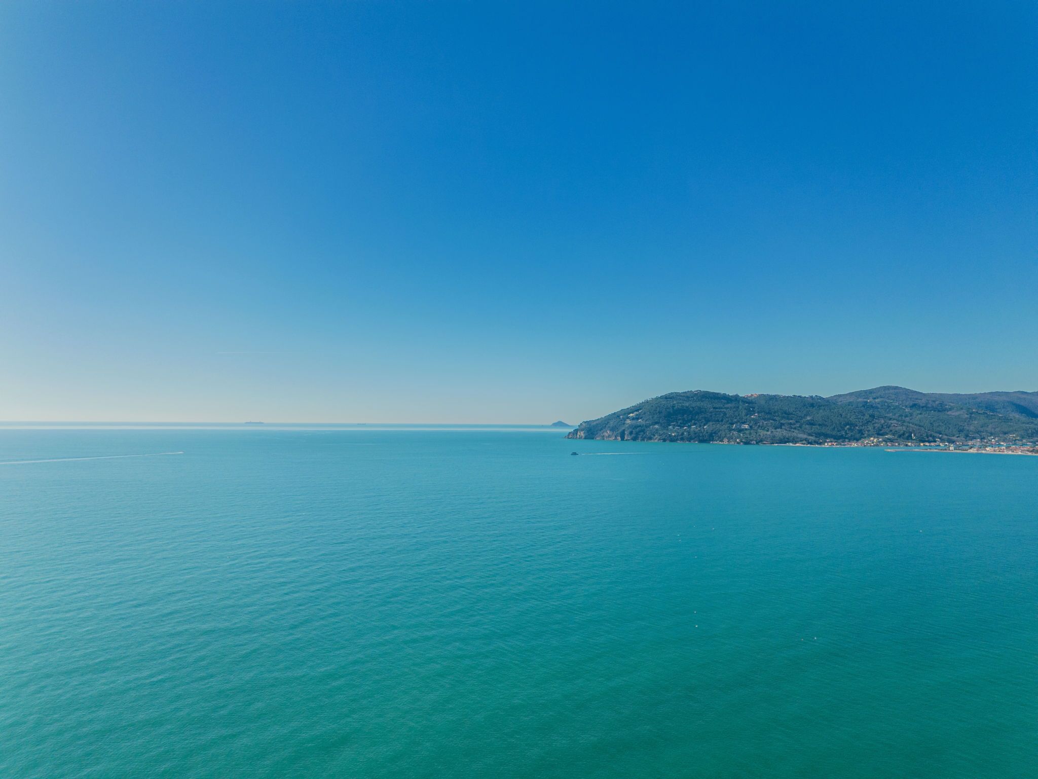 Un paysage côtier offrant une vue dégagée sur une petite île et une mer calme.