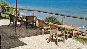 A beachside seating area with wicker chairs and a white umbrella, overlooking the sea. - Masseria Difesa Grande by Interhome (Montenero di Bisaccia)
