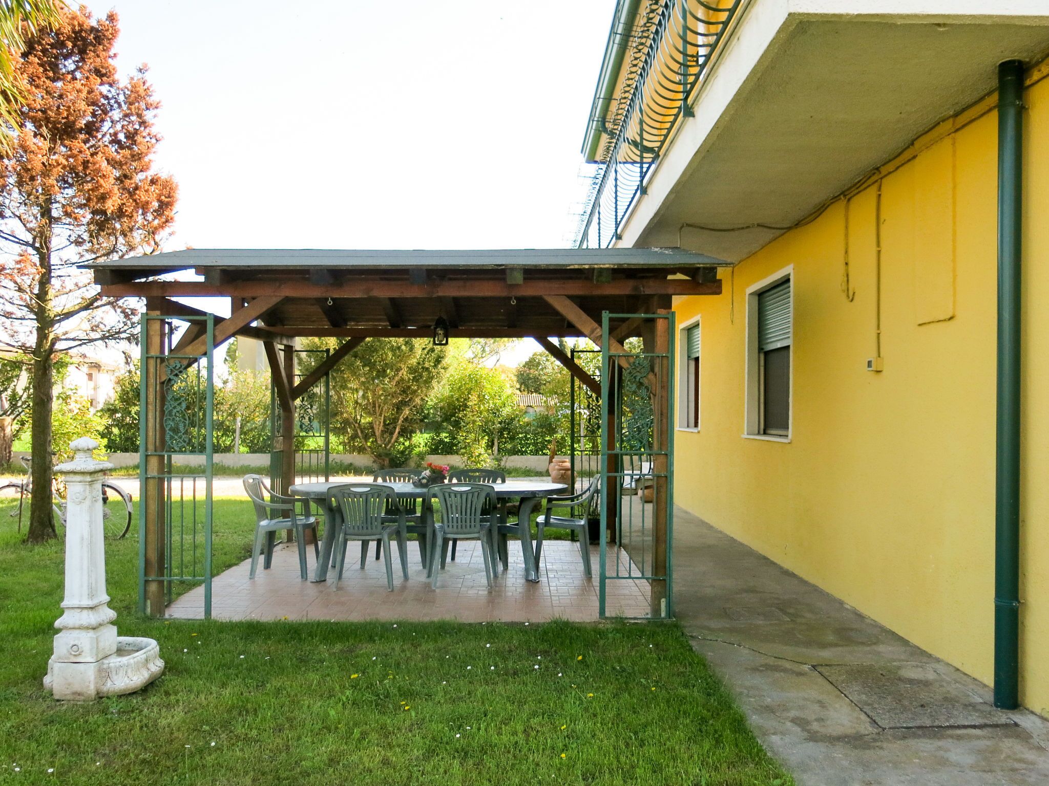 Un patio couvert avec des meubles d’extérieur et un jardin.