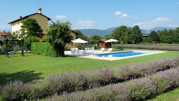 Um imóvel residencial com piscina, área de estar ao ar livre e um jardim com lavanda.