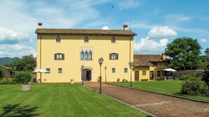 A large yellow building with a tiled roof, a central entrance, and a paved courtyard. - Domus Magna by Interhome (Povoletto)