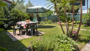 A patio with a table and chairs, surrounded by greenery and a fence. - Il Castelliere by Interhome (Rive d’Arcano)