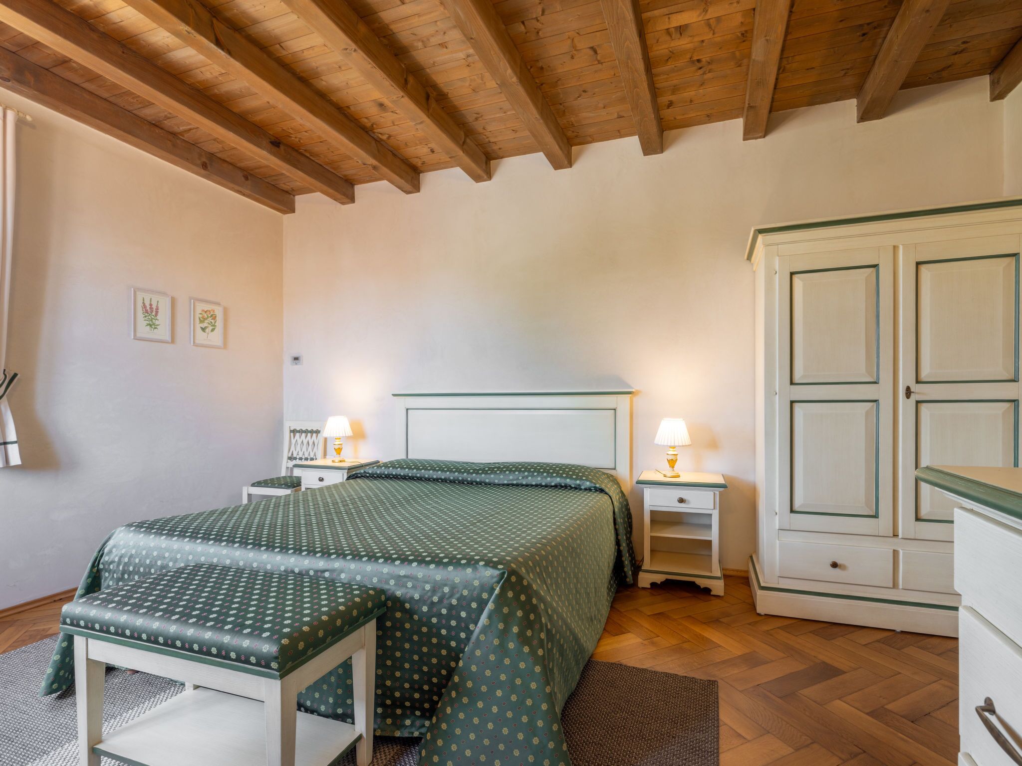 Une chambre à coucher comprenant un lit, des tables de chevet, une commode et une armoire.