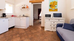 Un espace de vie compact comprenant une kitchenette, un coin repas et un salon.