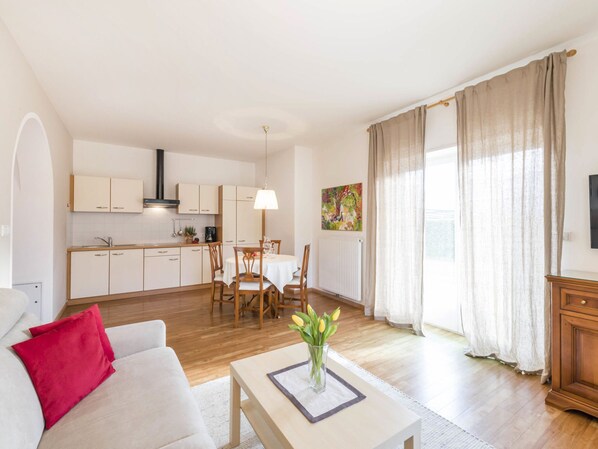 A modern apartment with a kitchen, dining area, and living room.