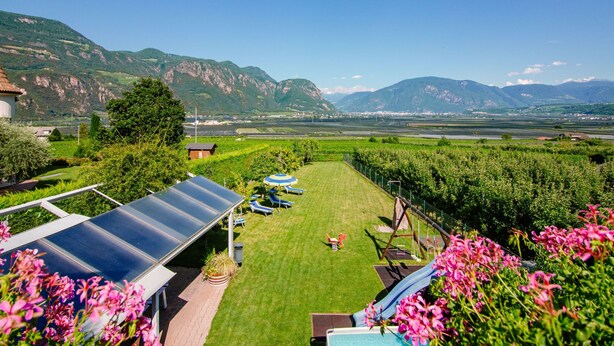 A vineyard with a solar panel, a grassy area with a swing set, and mountains in the background. - Rosengartenhof by Interhome (Andriano)
