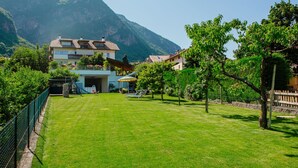 A residential area with a well-maintained lawn, a house with a balcony, and a mountain in the background. - Rosengartenhof by Interhome (Andriano)