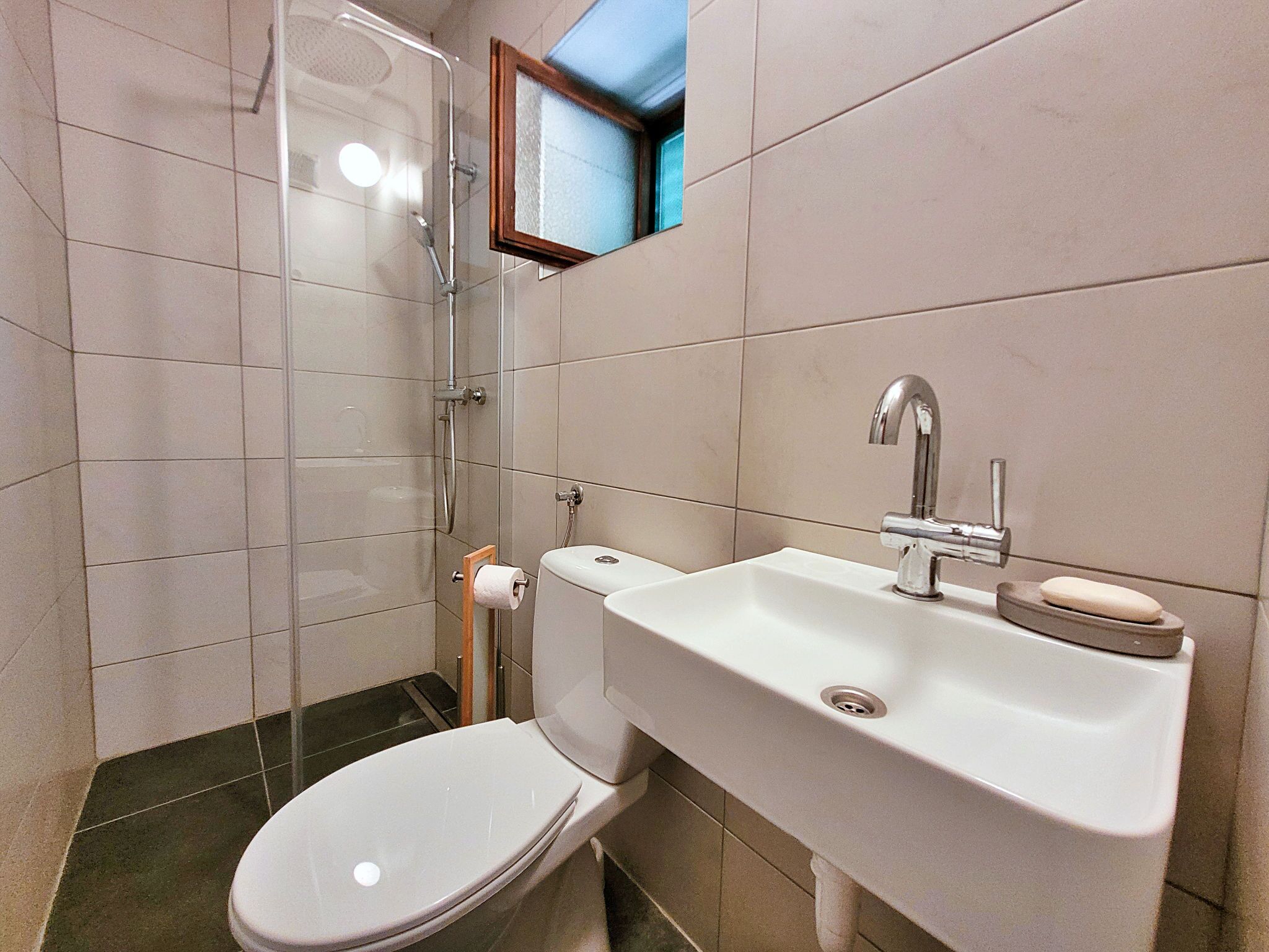 Ein Badezimmer mit Toilette, Waschbecken und Dusche.