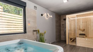 A modern bathroom with a bathtub, a shower, and a sauna. - Pinnidae by Interhome (Rab/Lopar)