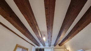 A room with exposed wooden beams on the ceiling, a framed picture on the wall, and an air conditioning unit. - Gesuiti Cozy and Central Apartment by Ca-sa Check (Venice)
