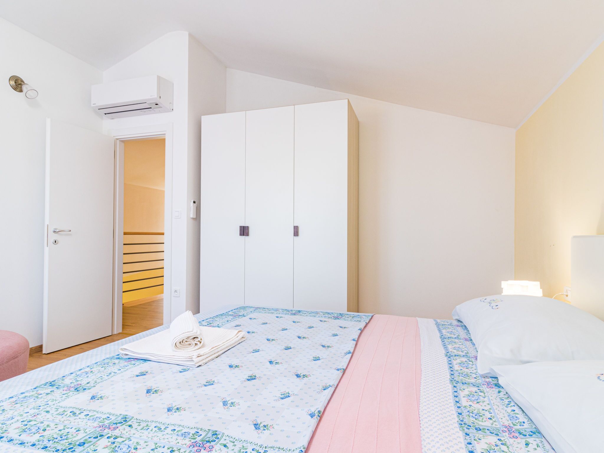 Ein Schlafzimmer mit einem Bett, einem Kleiderschrank und einer Klimaanlage.