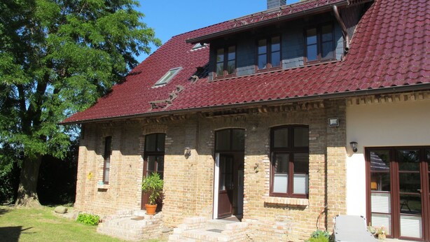 A two-story brick house with a red-tiled roof, a front porch, and a small garden area. - Apartment Helene by Interhome (Ribnitz-Damgarten)