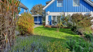 A blue house with a garden, a patio, and a satellite dish. - Achterblick 2 by Interhome (Seebad Altefähr)