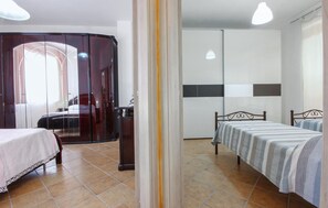 Comfortable room with a large bed, a smaller bed, and a desk area.