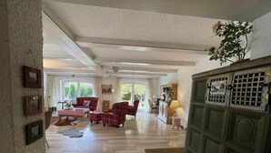 Ein geräumiges Wohnzimmer mit Kamin, Essbereich und Blick ins Freie.