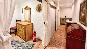 A room with a wooden dresser, a mirror, a fire extinguisher, a patterned rug, and a painting on the wall. - Holiday Home am Bostalsee by Interhome (Oberthal)