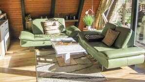 A cozy living room with a green sofa set, a coffee table, and a potted plant. - Winnetou by Interhome (Ronshausen)