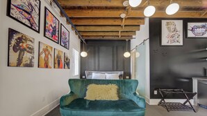 A modern living room with a teal sofa, a wooden ceiling, and artwork on the walls. - Westlake Hotel - The Art Suite (Etobicoke)
