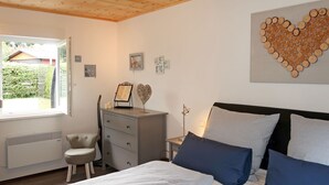 A bedroom with a bed, a dresser, a chair, a desk, and a window. - Vacation home Caro by Interhome (Kirburg)