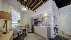 Une cuisine moderne dotée d’un îlot central, d’appareils électroménagers intégrés et d’un revêtement mural hexagonal.
