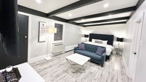 Un dormitorio moderno con una cama grande, un sofá azul y una mesa de centro blanca.