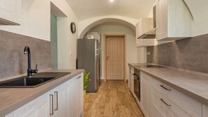 A modern kitchen with light wood cabinets, a stainless steel sink, and a built-in oven. - Pool & Wellness Estate by Interhome (Destne v Orlickych Horach)