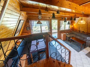A wooden cabin interior with a staircase, seating area, and large windows. - Lake & Rest by Interhome (Strizovice)