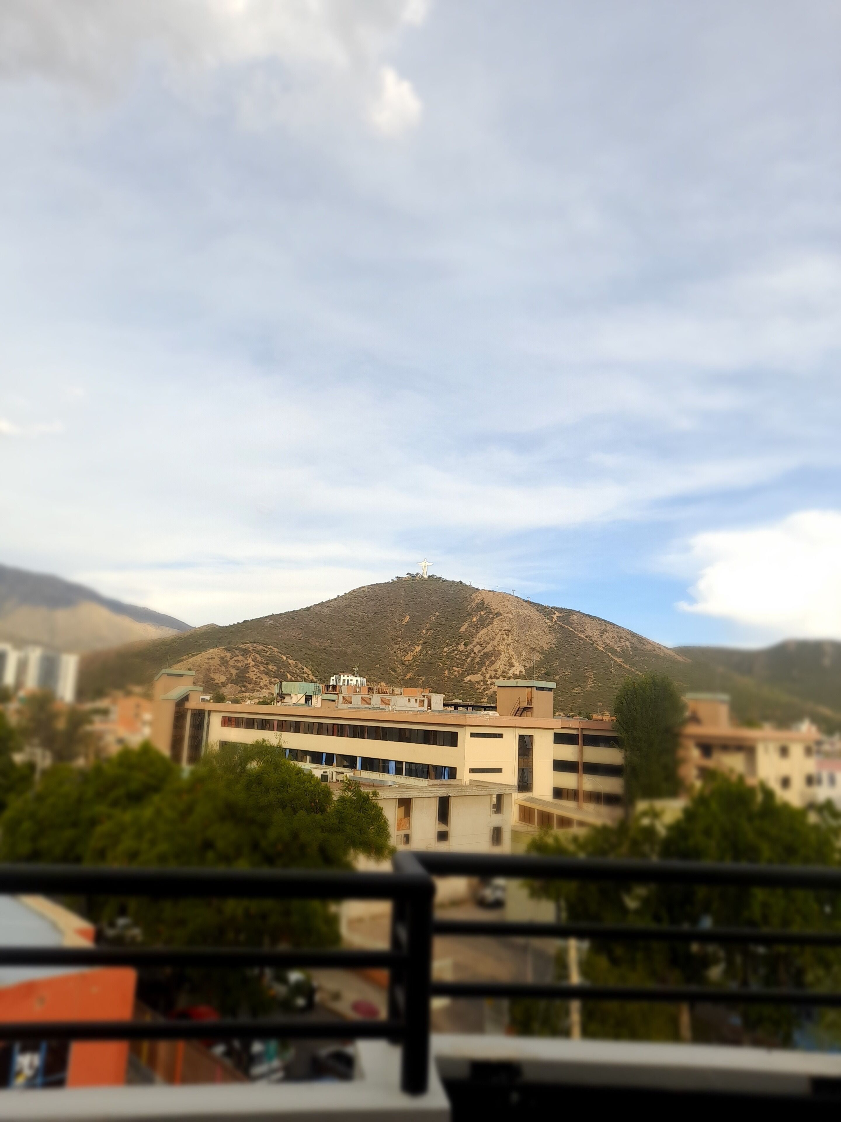 Une vue d’une région montagneuse, avec des bâtiments au premier plan.