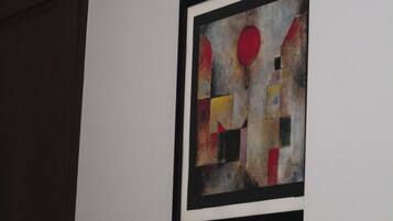 A wall with a framed abstract painting and a door.